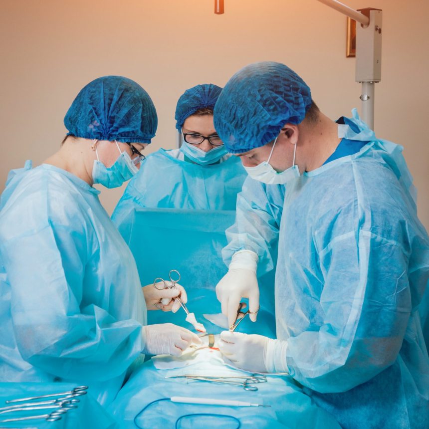 Group of surgeons in operating room with surgery equipment. Background